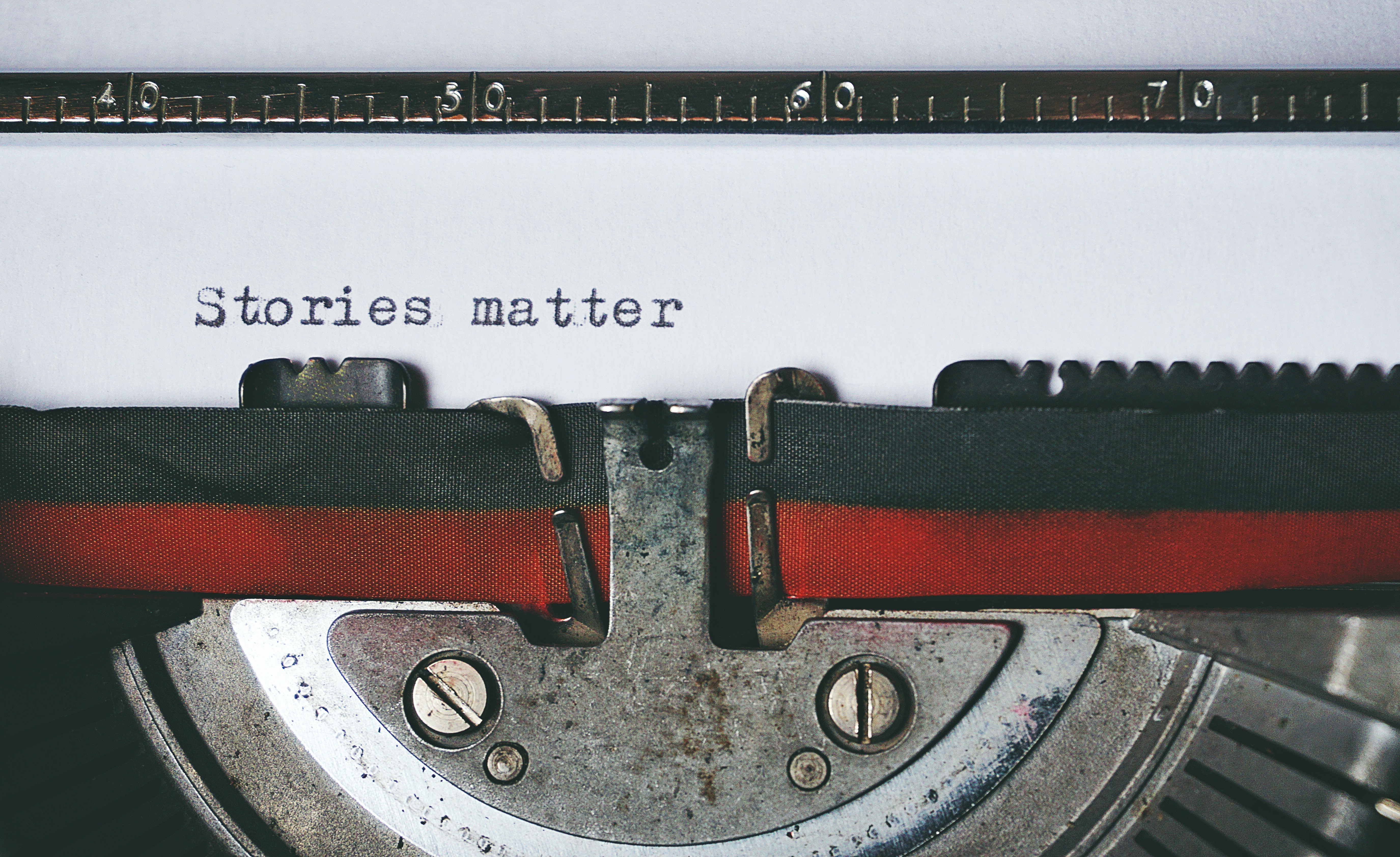 Close up of a typewriter with the words "stories matter" typed on the paper 